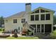 Exterior featuring a large screened porch, patio, and manicured lawn at 4046 Water Hole Ct, Douglasville, GA 30135