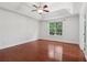 Bright bedroom featuring a ceiling fan, wood floors, and a large window at 4046 Water Hole Ct, Douglasville, GA 30135
