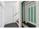 Mudroom with a built-in storage bench, coat hooks, and dark-colored tile floors near a white door at 4046 Water Hole Ct, Douglasville, GA 30135