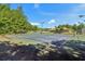 Tennis court that is lighted and fenced-in with a view of the pond and clubhouse at 4046 Water Hole Ct, Douglasville, GA 30135