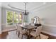 Elegant dining room with wainscoting, chandelier, and large window offering natural light at 5007 Highland Oaks Se Ct, Smyrna, GA 30126