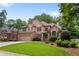 Charming brick two-story home featuring a well-manicured lawn, attached garage, and mature landscaping at 5007 Highland Oaks Se Ct, Smyrna, GA 30126