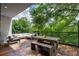 A spacious balcony with wood floors, a rustic table with benches, and a cozy couch at 670 Willoughby Ne Way, Atlanta, GA 30312