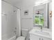 Bathroom with tub/shower combo, vanity and framed mirror viewing bedroom and outdoor greenery at 670 Willoughby Ne Way, Atlanta, GA 30312