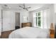 This light-filled bedroom has hardwood floors, white walls, a ceiling fan, and a dresser at 670 Willoughby Ne Way, Atlanta, GA 30312