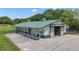 Spacious barn with multiple stalls, green metal roof, white siding and large sliding doors, perfect for equestrian enthusiasts at 14501 Woolsey Rd, Hampton, GA 30228