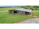 Rustic, weathered barn with open bays, providing a vintage charm and functional space for storage or agricultural activities at 14501 Woolsey Rd, Hampton, GA 30228