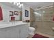 Bright bathroom featuring a white vanity, framed mirrors, and a glass-enclosed shower with tile surround at 14501 Woolsey Rd, Hampton, GA 30228