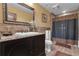 Elegant bathroom with black vanity, stone tile shower and flooring, and decorative mirror at 14501 Woolsey Rd, Hampton, GA 30228