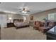 Spacious bedroom featuring neutral carpeting, stylish furnishings, and a ceiling fan for added comfort at 14501 Woolsey Rd, Hampton, GA 30228