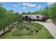 Inviting log-style home with a covered porch and beautifully landscaped pond at 14501 Woolsey Rd, Hampton, GA 30228