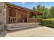 Charming log cabin exterior featuring a covered porch with stone accents and landscaping at 14501 Woolsey Rd, Hampton, GA 30228