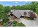 Gorgeous home featuring a log facade, a stone water feature, professional landscaping and circular driveway at 14501 Woolsey Rd, Hampton, GA 30228