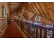 Hallway with open vaulted ceiling and a rustic railing overlooking living area at 14501 Woolsey Rd, Hampton, GA 30228