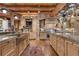 Spacious kitchen featuring stone archways, exposed beams, professional appliances, and pot rack at 14501 Woolsey Rd, Hampton, GA 30228