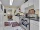 Galley kitchen featuring white cabinetry, stainless steel appliances, and tile flooring at 14501 Woolsey Rd, Hampton, GA 30228