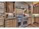 Kitchen with stainless steel range, custom cabinets, and a stone accented range hood at 14501 Woolsey Rd, Hampton, GA 30228