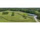 Picturesque aerial view of fenced land with a barn, perfect for equestrian activities or rural living at 14501 Woolsey Rd, Hampton, GA 30228
