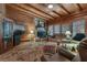 Cozy living room featuring a stone fireplace, wood-beamed ceilings, and comfortable seating at 14501 Woolsey Rd, Hampton, GA 30228