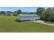 Large outbuilding with roll up door and green trim on a spacious lot at 14501 Woolsey Rd, Hampton, GA 30228
