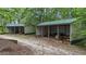 Multiple open-sided outbuildings provide ample storage on the property at 14501 Woolsey Rd, Hampton, GA 30228
