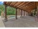Covered patio with wood ceiling, stone fireplace, with views of the pool and garage at 14501 Woolsey Rd, Hampton, GA 30228