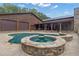 Inviting pool and jacuzzi with stone surround, nestled next to a log home with a covered outdoor area at 14501 Woolsey Rd, Hampton, GA 30228