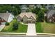 Aerial view of a traditional home with lush green lawn, mature trees, and a two-car garage at 1511 Rocky Knoll Ln, Dacula, GA 30019