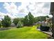 Spacious backyard with lush green grass, mature trees, and a cozy patio area for outdoor relaxation and entertainment at 1511 Rocky Knoll Ln, Dacula, GA 30019