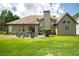 Expansive backyard with a wooden deck, outdoor seating, lush greenery, and well-maintained lawn at 1511 Rocky Knoll Ln, Dacula, GA 30019