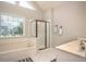 Bathroom with garden tub, glass shower, and tile floors at 1511 Rocky Knoll Ln, Dacula, GA 30019