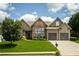 Charming home featuring a well-manicured lawn, stone accents, and an attached two-car garage at 1511 Rocky Knoll Ln, Dacula, GA 30019