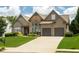 Charming home featuring a well-manicured lawn, stone accents, and an attached two-car garage at 1511 Rocky Knoll Ln, Dacula, GA 30019