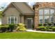 Stately home featuring a manicured front yard and elegant entrance with a mix of stone and siding at 1511 Rocky Knoll Ln, Dacula, GA 30019