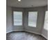 Bright bedroom with wood-look floors, white walls, and two large windows at 746 Great Oak Pl, Villa Rica, GA 30180