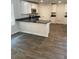 Open kitchen with white cabinets, granite countertops, stainless appliances, and wood-look floors at 746 Great Oak Pl, Villa Rica, GA 30180