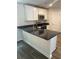 Modern kitchen featuring white cabinets, stainless steel appliances, and a black granite countertop at 746 Great Oak Pl, Villa Rica, GA 30180