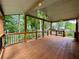 A spacious back porch with a wooden deck and a view of the serene, wooded backyard at 851 Millvale Pl, Lawrenceville, GA 30044