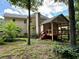 Backyard view of a home with a back porch, trees, and grass at 851 Millvale Pl, Lawrenceville, GA 30044
