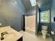 Bright bathroom featuring a bathtub, toilet, and a sink with blue walls at 851 Millvale Pl, Lawrenceville, GA 30044