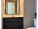 Half bathroom featuring a black vanity with a decorative mirror and a white countertop at 851 Millvale Pl, Lawrenceville, GA 30044