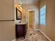 Well-lit bathroom vanity with granite countertop, open storage, and a decorative mirror at 851 Millvale Pl, Lawrenceville, GA 30044