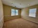 A well-lit room with two windows and neutral carpeting, offering a versatile space at 851 Millvale Pl, Lawrenceville, GA 30044
