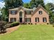 Beautiful two-story brick home with manicured lawn and mature trees at 851 Millvale Pl, Lawrenceville, GA 30044