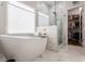 Luxurious bathroom offers a soaking tub, a separate glass shower, and marble tile at 1472 Lynchburg Pl, Marietta, GA 30062