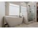 Bathroom featuring a stand alone tub, a glass shower door and marble floors and walls at 1472 Lynchburg Pl, Marietta, GA 30062