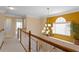 Upstairs hallway featuring hardwood railing and a window with a view of the home's manicured landscaping at 1472 Lynchburg Pl, Marietta, GA 30062