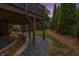 View of stone water feature running under the deck surrounded by lush greenery and professional landscaping at twilight at 1701 Clay Brooke Se Ct, Smyrna, GA 30082