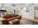 Cozy living room with hardwood floors, leather sofa, a colorful rug and an entry view to the kitchen at 1701 Clay Brooke Se Ct, Smyrna, GA 30082