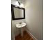 Elegant half bathroom with pedestal sink, framed mirror, and hardwood floors at 3202 Saute Way, Avondale Estates, GA 30002